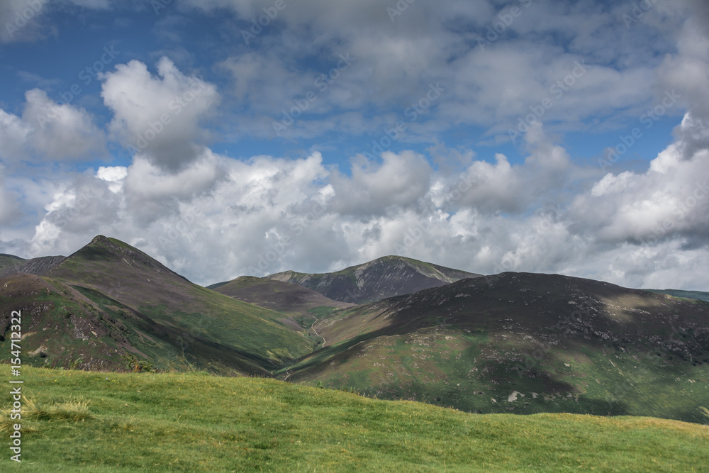 dramatic landscape with mountains, hills, lake and clouds formations dramatic landscape with mountains, hills, lake and clouds formations