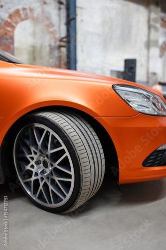 Orange car with alloy wheel indoor © Vladimir