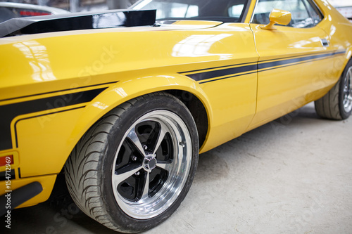 Yellow old muscle car with alloy wheel indoor