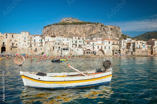 Unidentified people on sandy beach in Cefalu, Sicily, Italy