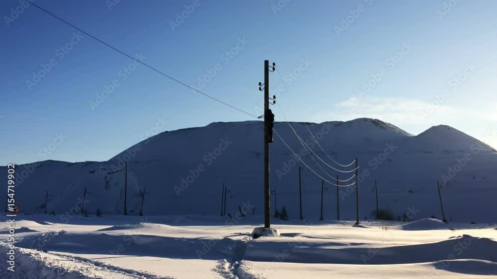 The worker on the pole cuts the contact wire. The worker on the pole cuts the contact wire.