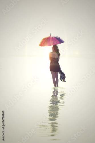 beautiful woman holding colorful umbrella on the beach in summer . Summer Vacation Concept. Filtered image processed vintage effect. 