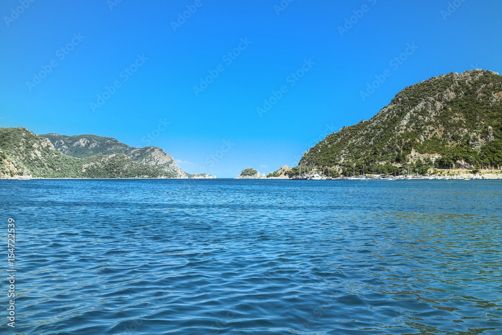 Summer touristic trip on Aegean sea: blue water and sky, green mountains