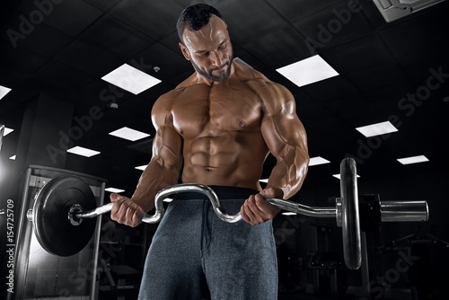 Adult guy bodybuilder posing in gym