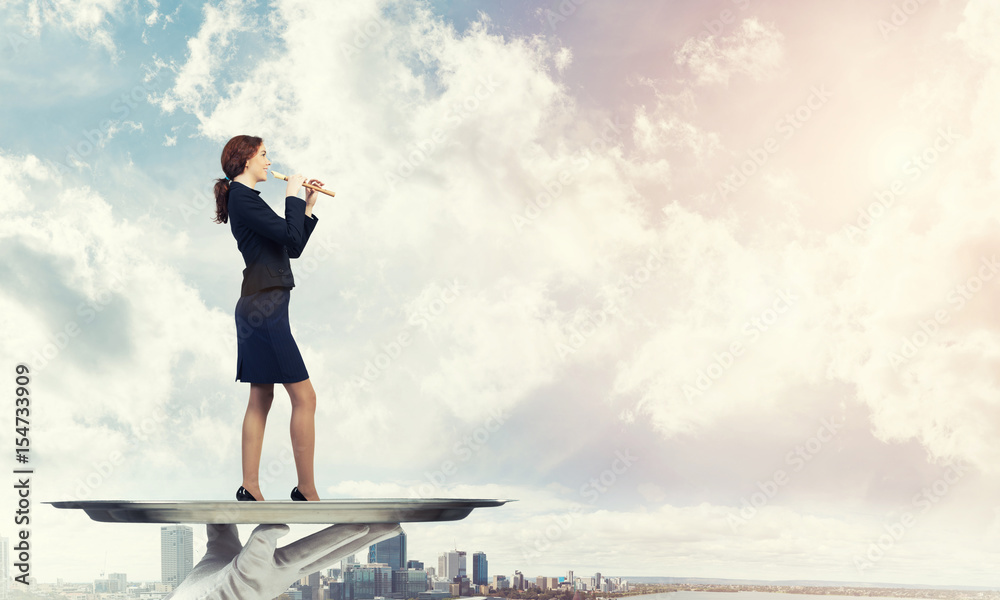 Obraz premium Attractive businesswoman on metal tray playing fife against cityscape background