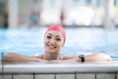 Beautiful woman cap smiling looking to camera at border of swimming pool © FS-Stock