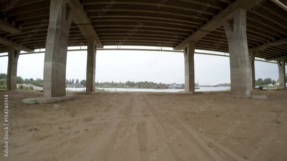 A view of the rural dirt road from camera installed on back of the car driving along this country road. The car bridge over the water meadows. Riding on a rough roadway. Traces of tires on the sand. A view of the rural dirt road from camera installed on back of the car driving along this country road. The car bridge over the water meadows. Riding on a rough roadway. Traces of tires on the sand.