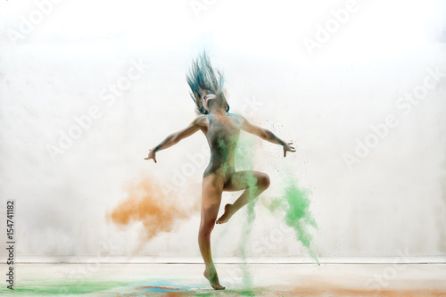 Sexy girl in a cloud of color dust studio portrait