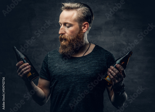 A man holds beer bottle. photo