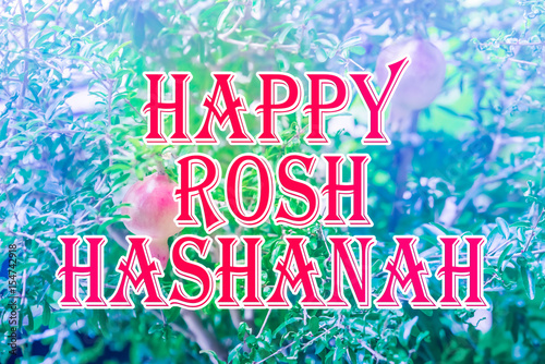 Happy Rosh Hashanah (Jewish New Year) lettering with growing red pomegranate on green branch background. It is held on the first (or second) day in September, marked by the blowing of the shofar. photo