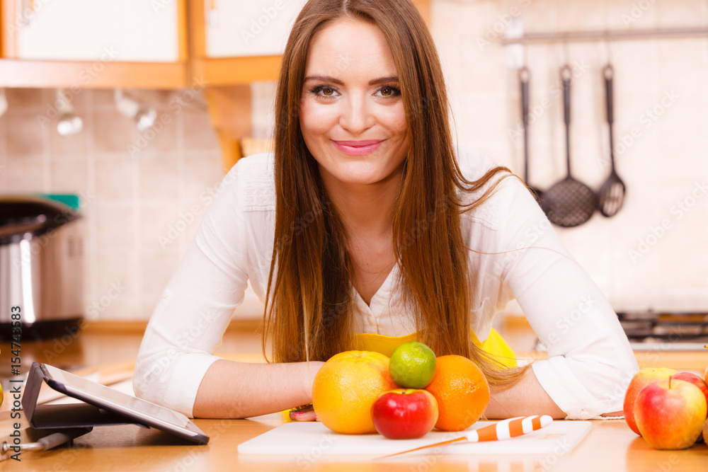 Woman housewife in kitchen using tablet