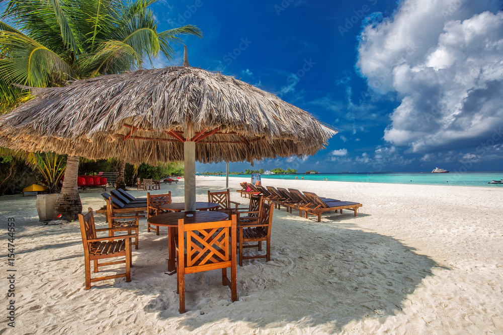 Table and chairs at the beach on tropical island in Indian ocean, Maldives