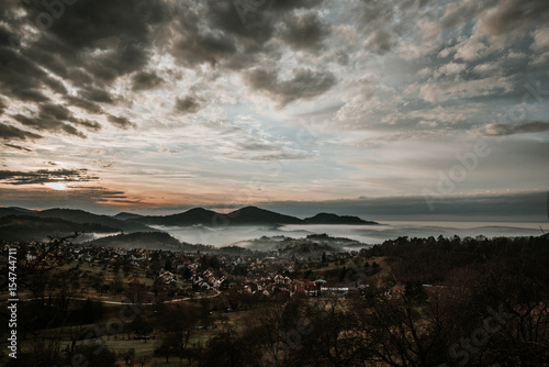 Village in the mountains with clouds and fog and sun in sunset