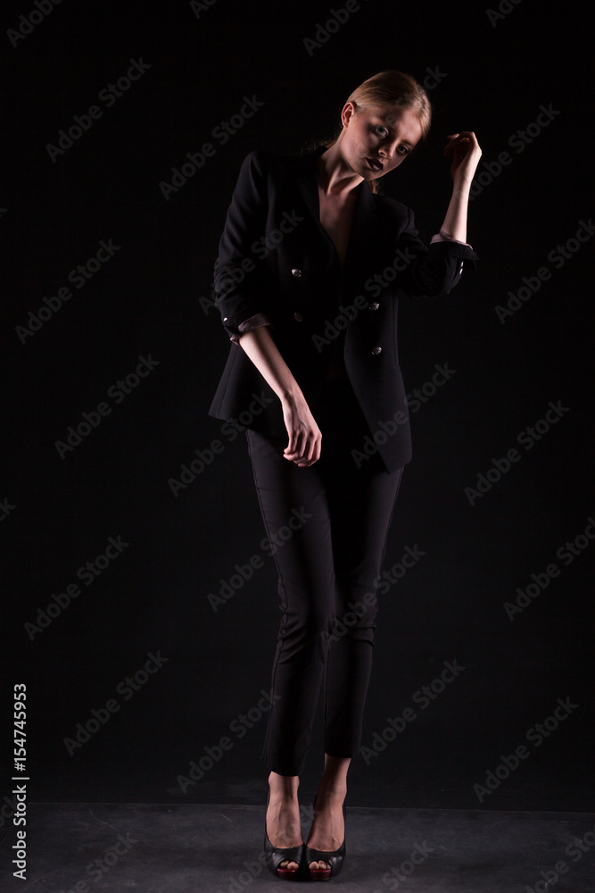 Woman in suit on black background in studio photo. Glamour and elegance Woman in suit on black background in studio photo. Glamour and elegance