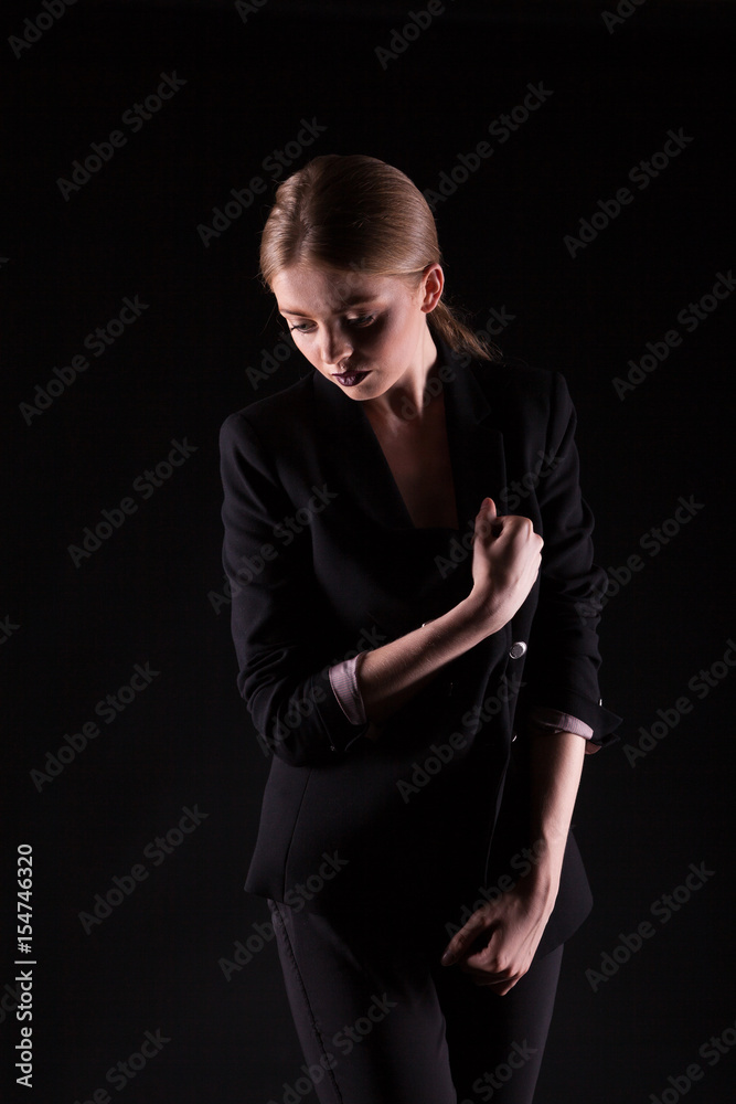 Woman in suit on black background in studio photo. Glamour and elegance Woman in suit on black background in studio photo. Glamour and elegance