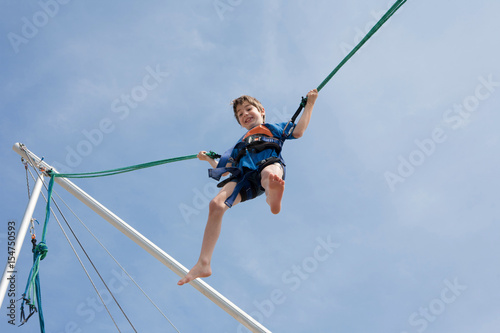 Obraz na plátně Young boy  enjoying jumping with trampoline jumping rope