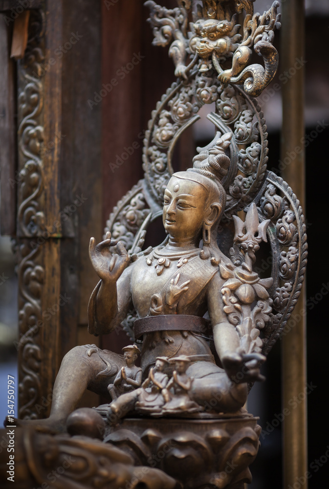 Ancient statue of a bodhisattva of Avalokiteshvara, made of bronze in nevara style, in the Golden Temple, Lalitpur, Kathmandu, Nepal.