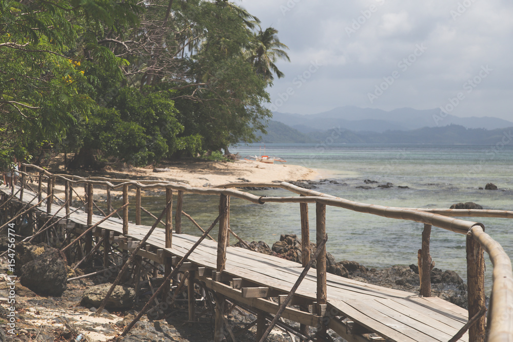 Obraz premium Long wooden bridge in beautiful tropical island beach - Philippines, the island of Palawan, next to El Nido.