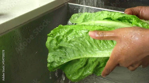 Washing lettuse in the sink. Slow Motion. photo