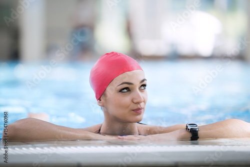 Beautiful woman cap smiling looking to camera at border of swimming pool © FS-Stock