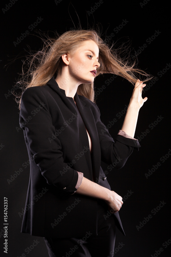 Beautiful sexy blonde woman posing in fashion style on black background in studio photo. Glamour and elegance Beautiful sexy blonde woman posing in fashion style on black background in studio photo. Glamour and elegance
