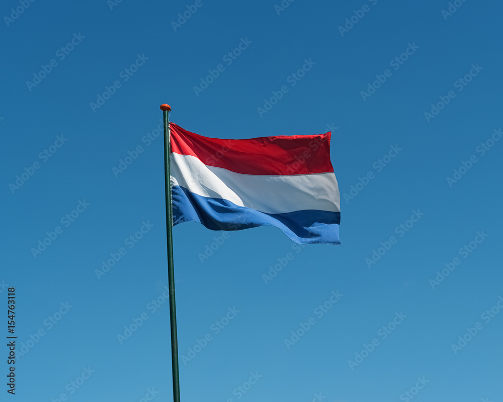 Flag of the Netherlands waving in wind, blue sky Flag of the Netherlands waving in wind, blue sky