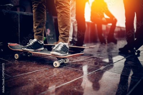 Skaters friends team outdoor in urban city with skateboards in their hands. Young people training longboard extreme sport. concept friendship. Warm filter