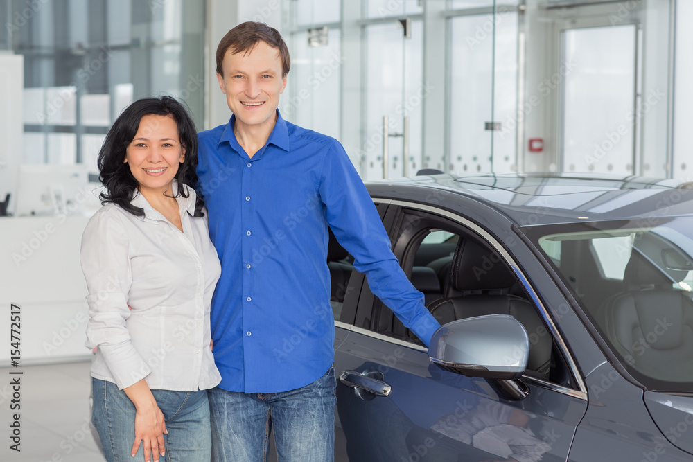 Mature couple choosing a new car at the dealership together
