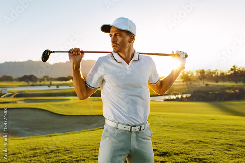 Male golfer with golf club at course