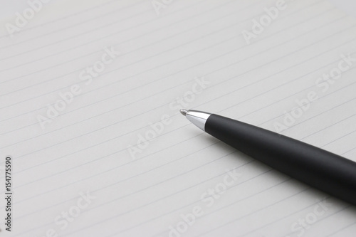 ノートの上に置かれた黒いボールペン © 35mmf2