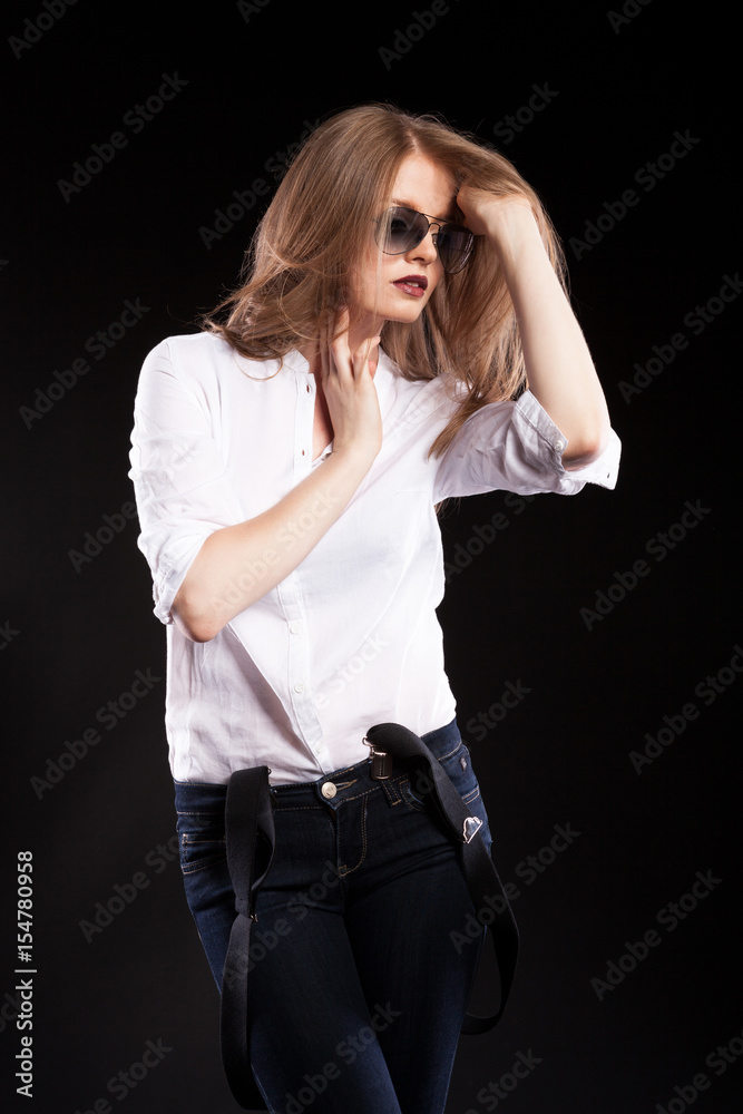 Sensual blonde model with suspenders and white shirt on black background in studio photo Sensual blonde model with suspenders and white shirt on black background in studio photo