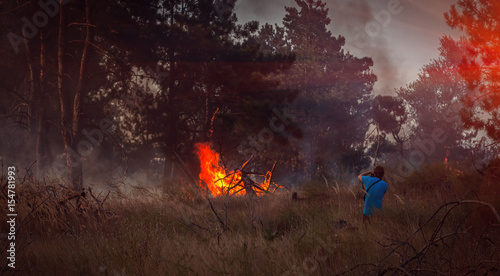 fire. forest fire is dangerous with person at sunset.