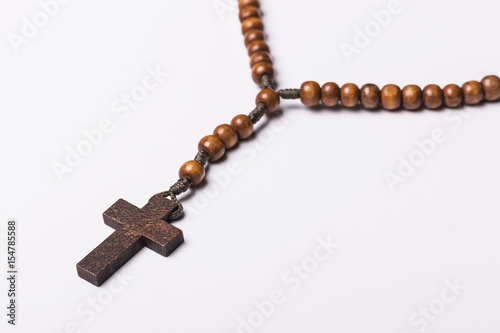 Rosary and a cross on a light gray background. 