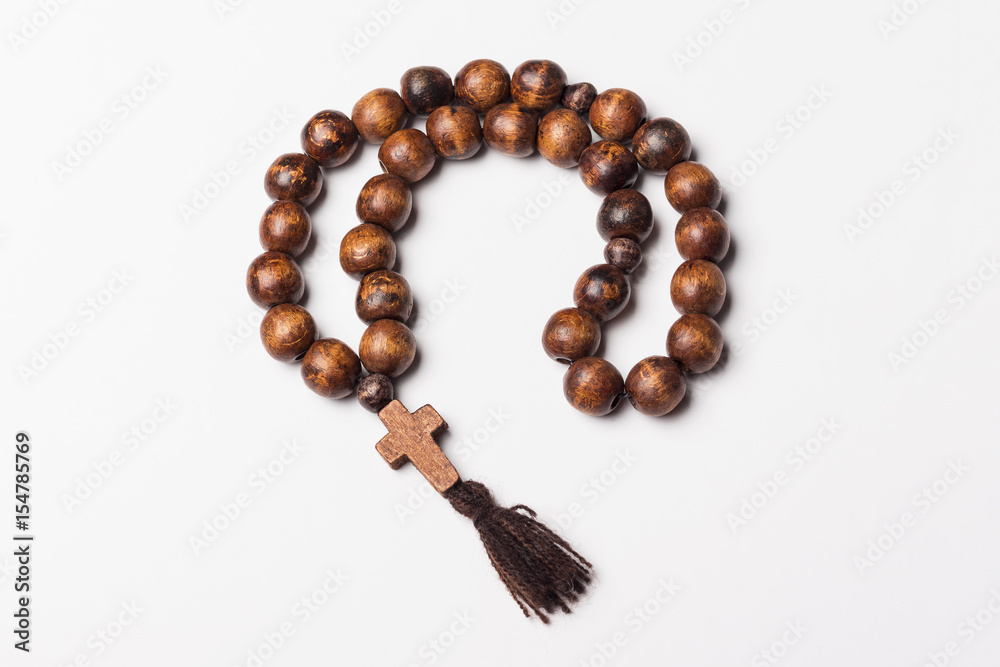 Rosary and a cross on a light gray background. Rosary and a cross on a light gray background.