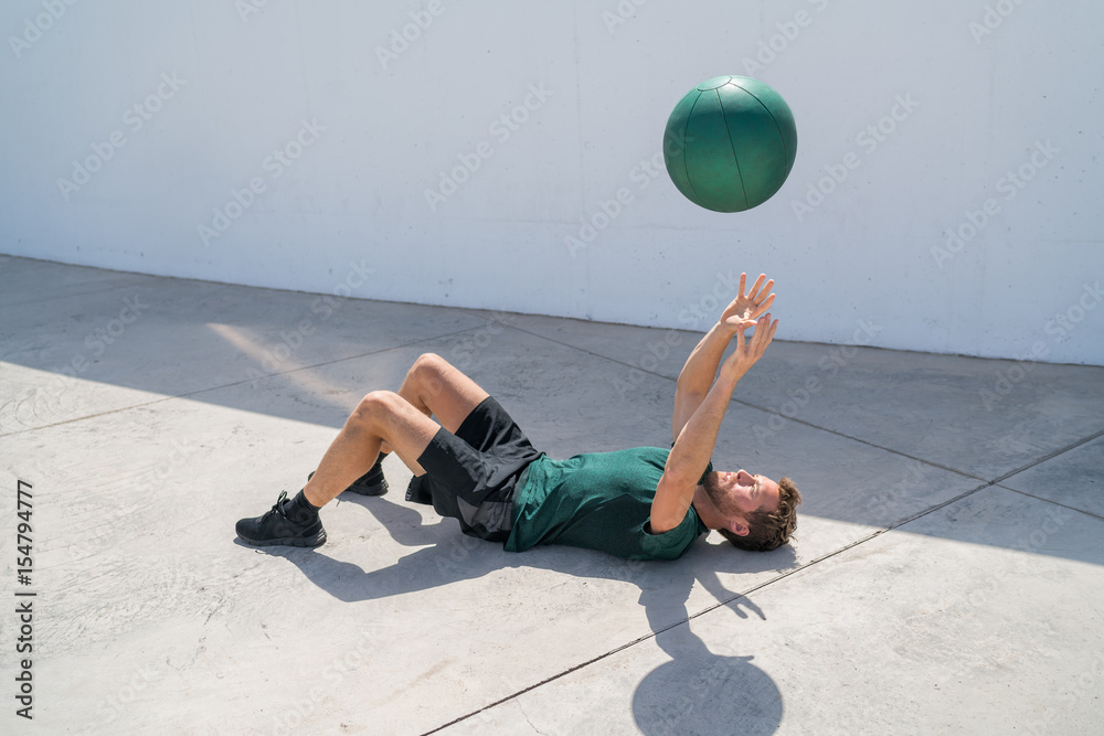 Strength training fit man cross training throwing medicine ball in the
