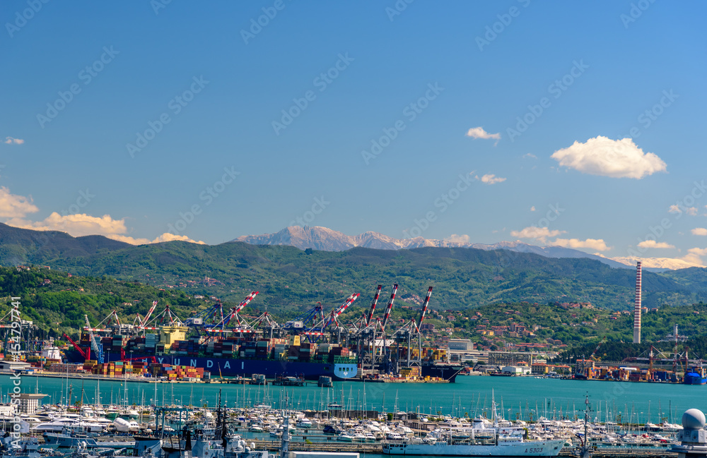 Obraz premium View of the port of La Spezia with boats and mountains at the horizon.