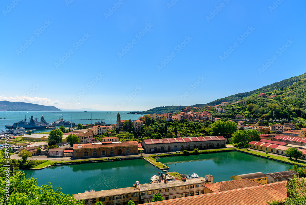 View of the port of La Spezia with boats and mountains at the horizon.
