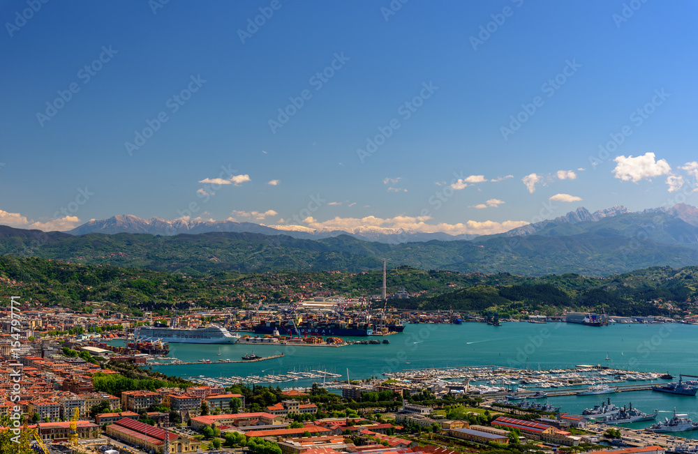 View of the port of La Spezia with boats and mountains at the horizon.