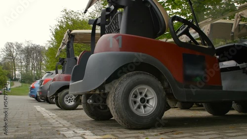 Golf carts parked In the covered wooden place photo