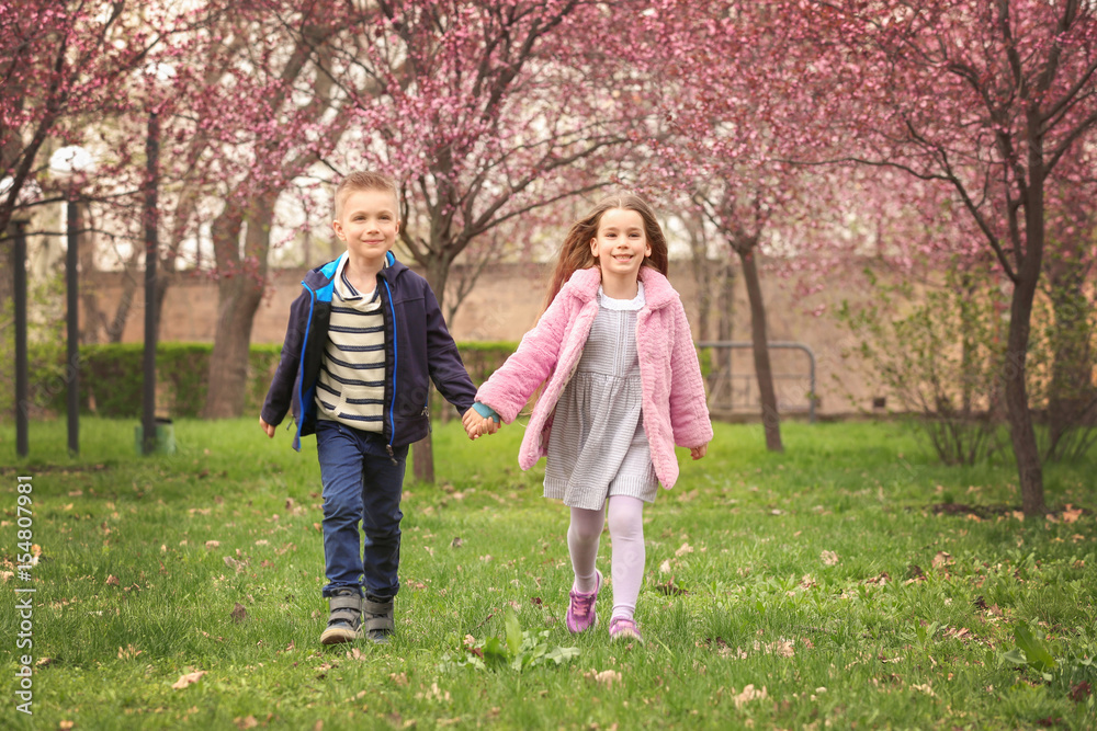 Pretty little girl and cute boy walking in spring park