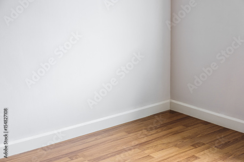 Laminated wood floor with white wall, room's corner