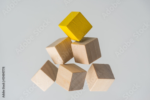 Картината върху платно Business concept - Abstract geometric real floating wooden cubes layout like triangle on grey background and it's not 3D render