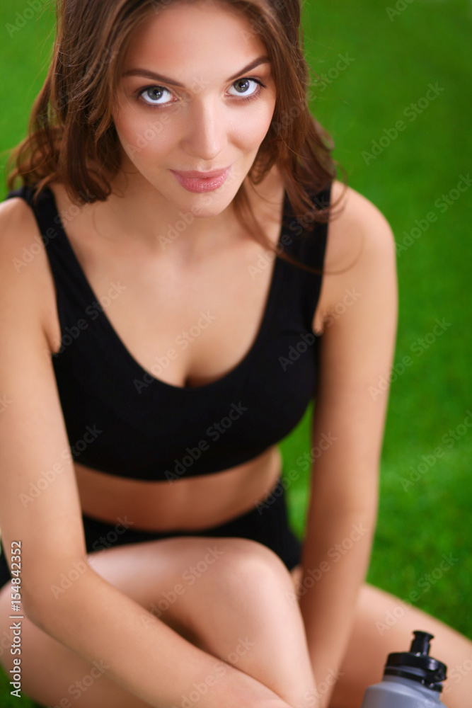 Fototapeta premium Woman sitting with crossed legs on the green grass