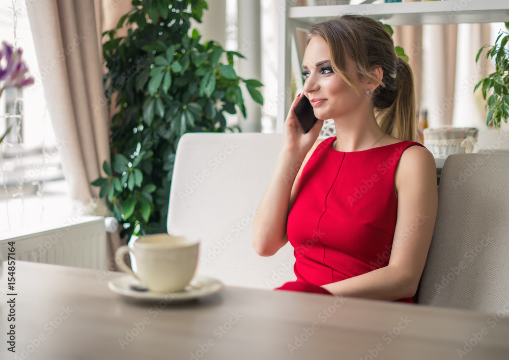 Businesswoman speaking on smartphone taking a coffee break. She is laughing. lady in red Businesswoman speaking on smartphone taking a coffee break. She is laughing. lady in red