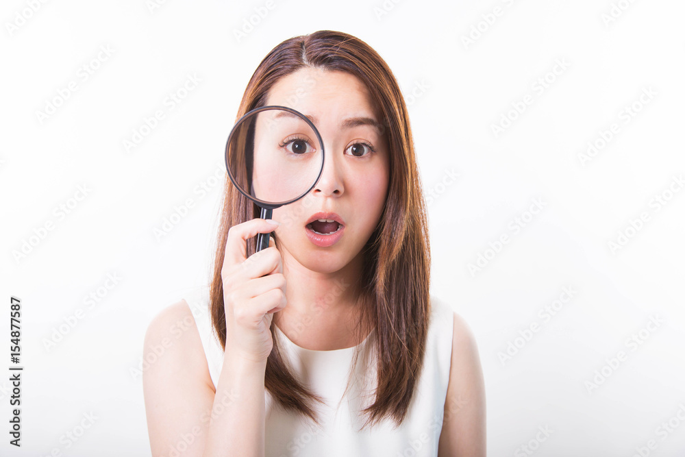 Surprised young woman looking through a magnifying glass on a white background Surprised young woman looking through a magnifying glass on a white background