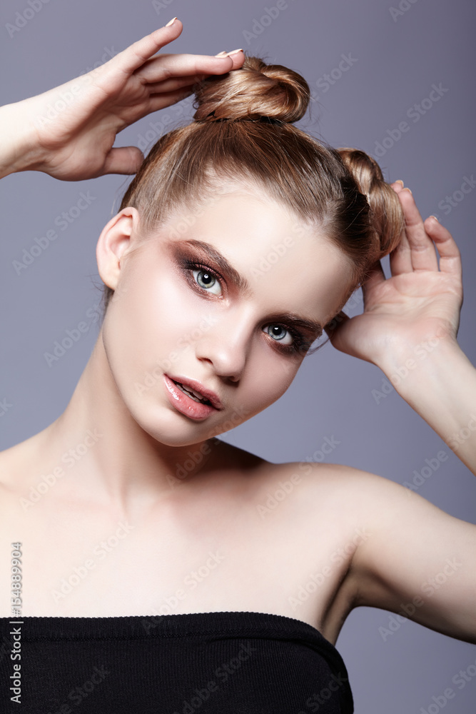 Fototapeta premium Young teen female beauty portrait with day makeup and bun hair style