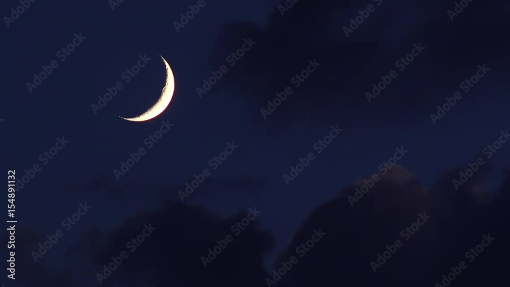Crescent moon in night sky with approaching clouds Crescent moon in night sky with approaching clouds