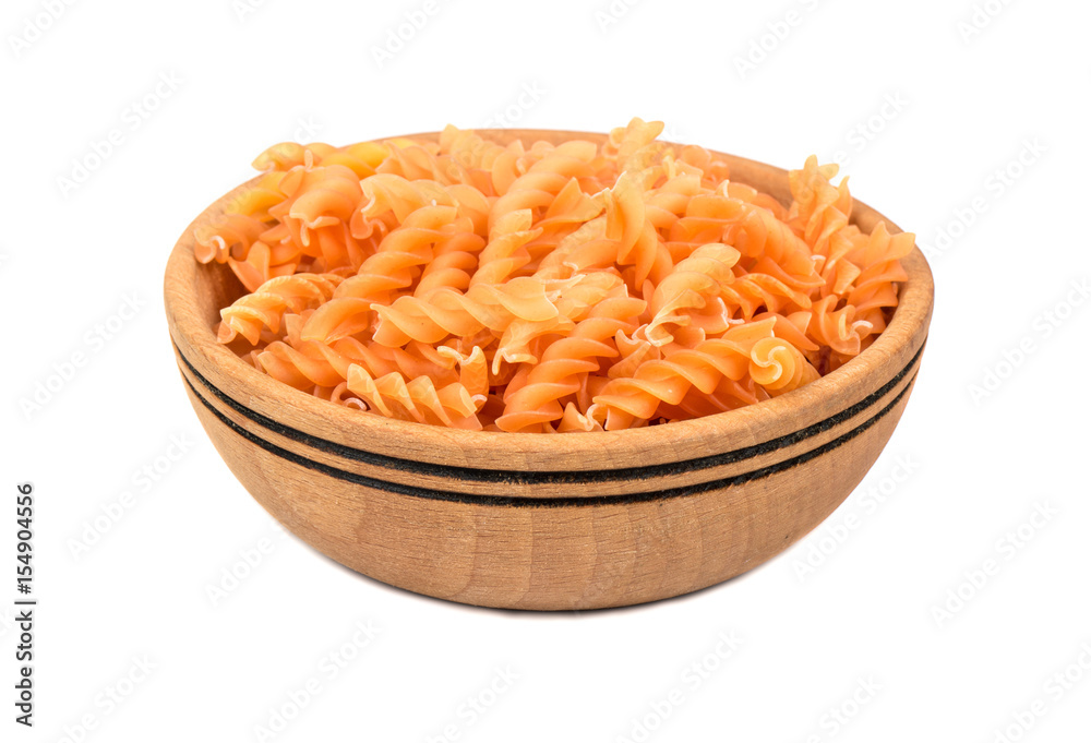 Uncooked pasta fusilli in a wooden bowl on a white background Uncooked pasta fusilli in a wooden bowl on a white background