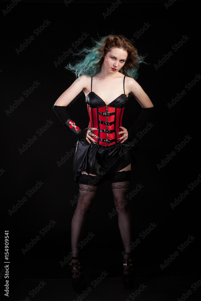 Gorgeous woman in fetish red leather corset on black background in studio photo. BDSM and dominatrix Gorgeous woman in fetish red leather corset on black background in studio photo. BDSM and dominatrix