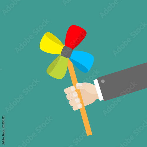 Businessman hand holding paper windmill pinwheel toy on stick. Green background. Isolated. Flat design